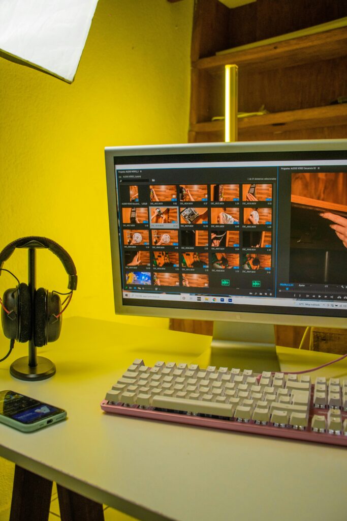 Modern home office setup featuring a monitor, keyboard, and headphones in a warm ambient lighting.